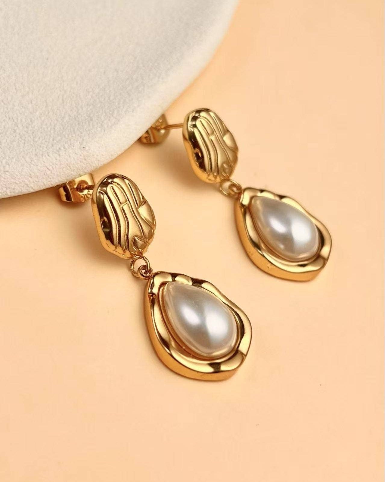 Nocatara Earrings elegant 18K gold-plated sculptural drop earrings featuring a pearlescent teardrop, photographed in soft neutral tones for a timeless Atelier ÉPURE look.