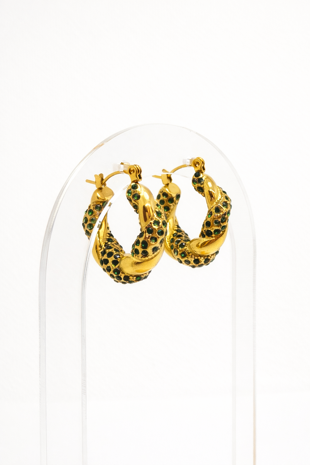 Gold twisted hoop earrings with green zirconia stones by Atelier Épure — bold, elegant, and refined.