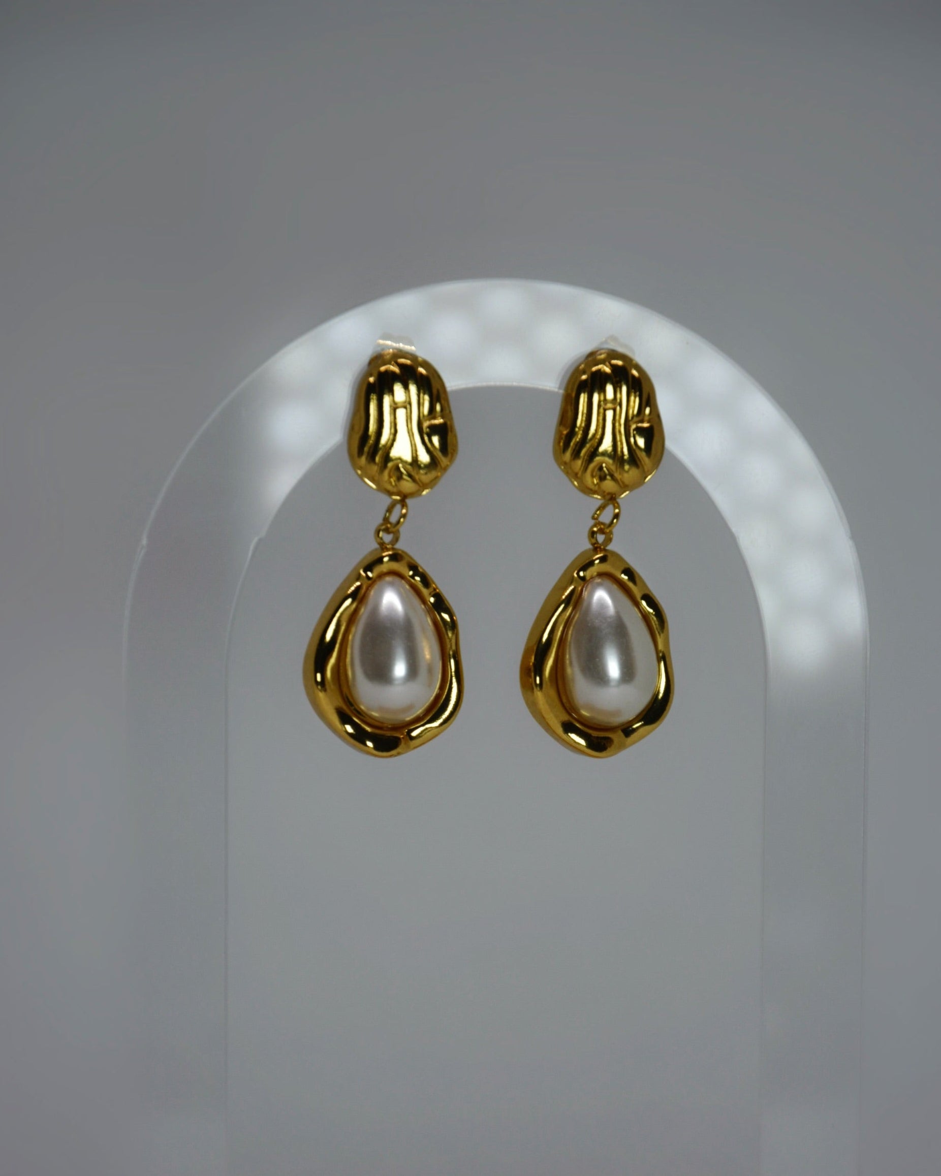 Nocatara Earrings elegant 18K gold-plated sculptural drop earrings featuring a pearlescent teardrop, photographed in soft neutral tones for a timeless Atelier ÉPURE look.