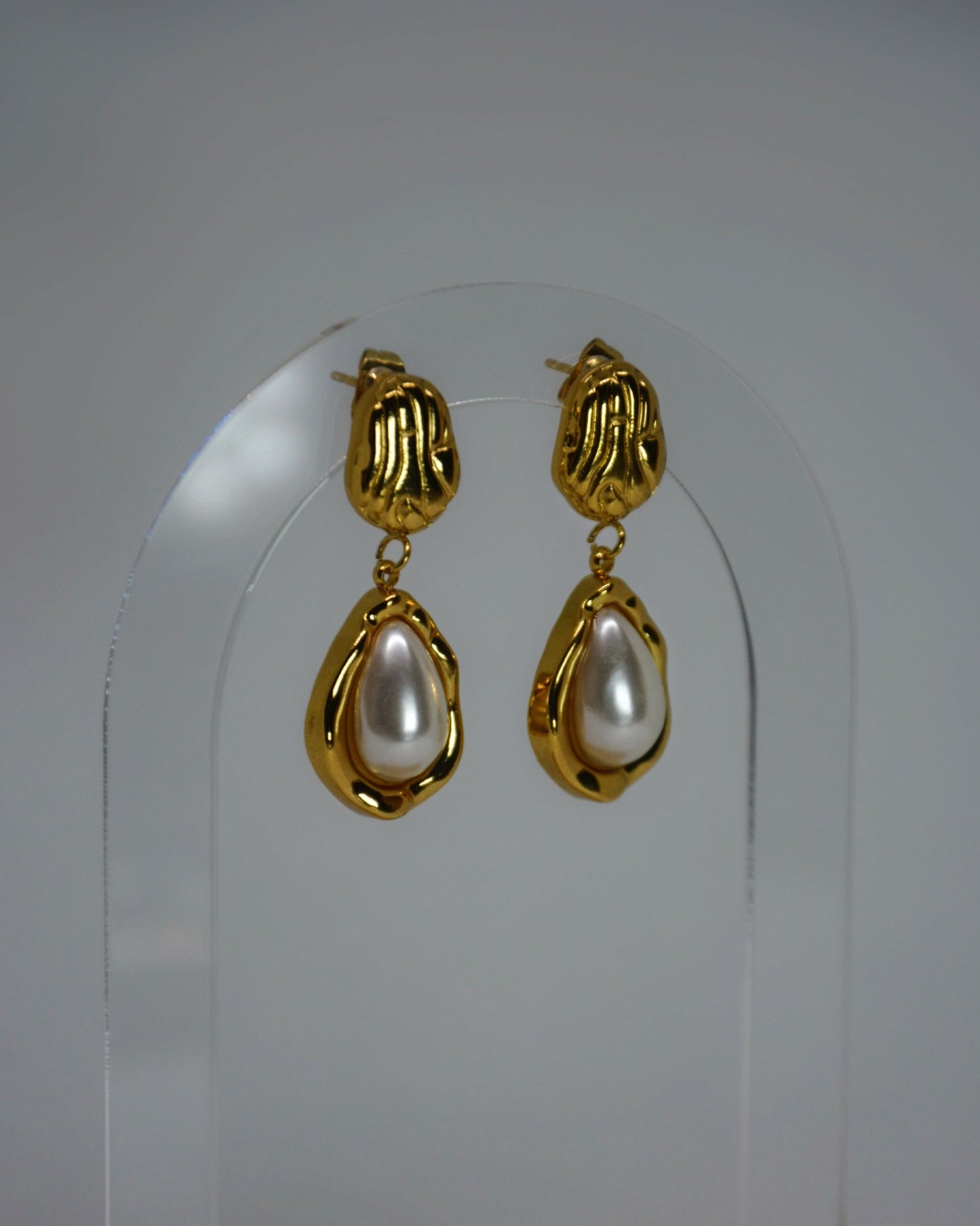 Nocatara Earrings elegant 18K gold-plated sculptural drop earrings featuring a pearlescent teardrop, photographed in soft neutral tones for a timeless Atelier ÉPURE look.