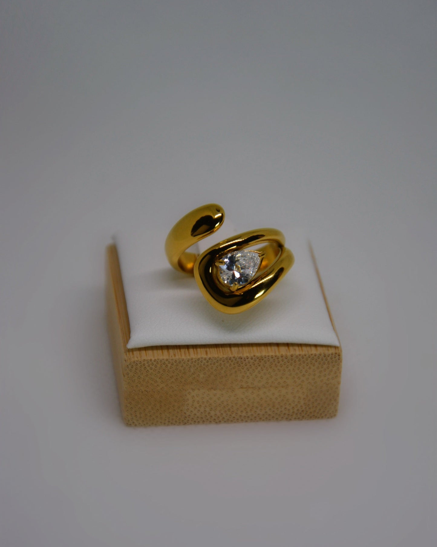 Evoke, an 18K gold-plated stainless steel wrap ring with a CZ crystal by Atelier ÉPURE. Elegant, sculptural, and crafted for everyday sophistication.