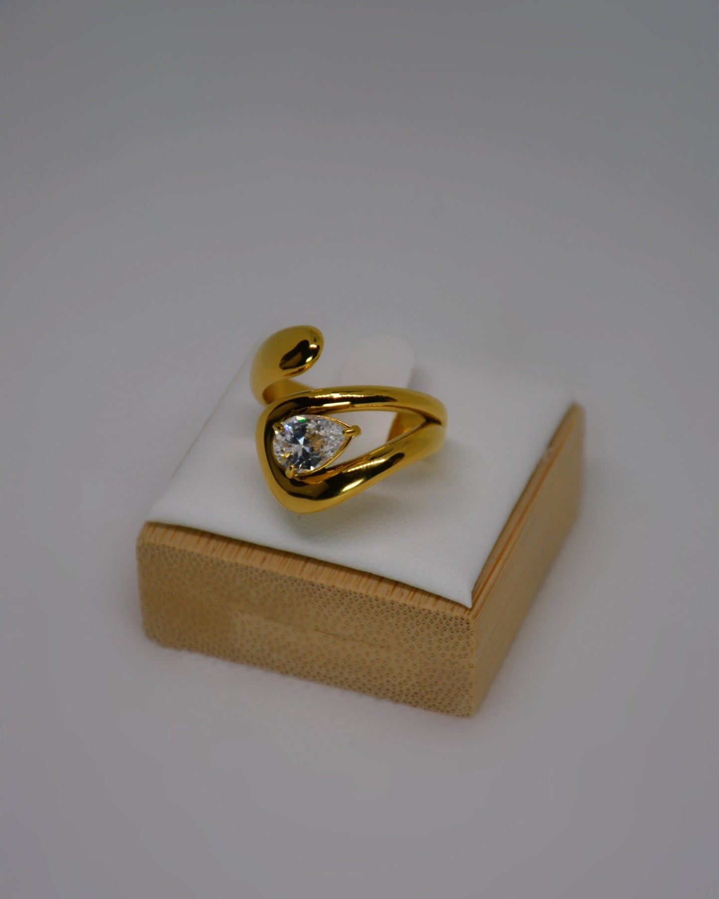 Evoke, an 18K gold-plated stainless steel wrap ring with a CZ crystal by Atelier ÉPURE. Elegant, sculptural, and crafted for everyday sophistication.
