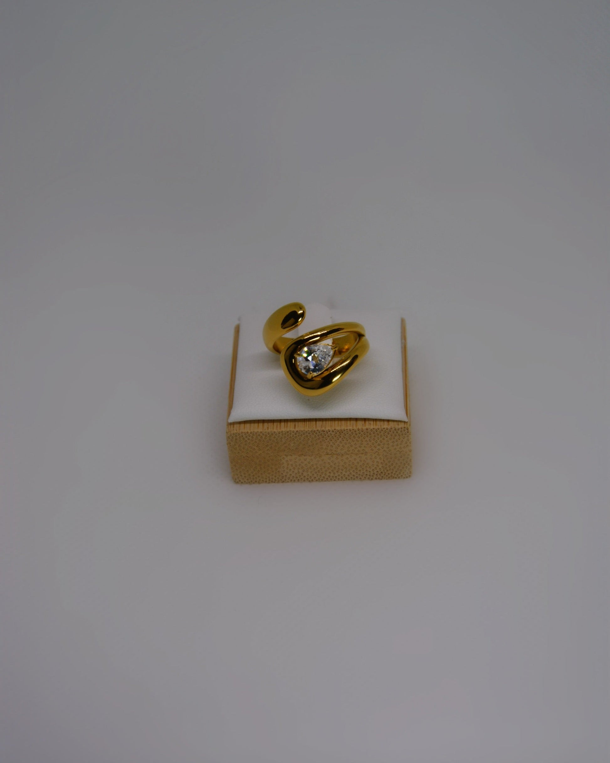 Evoke, an 18K gold-plated stainless steel wrap ring with a CZ crystal by Atelier ÉPURE. Elegant, sculptural, and crafted for everyday sophistication.